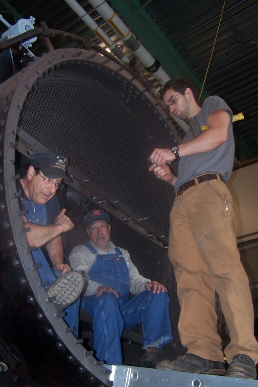 Crew of workers installing baffle screens inside of a locomotive boiler