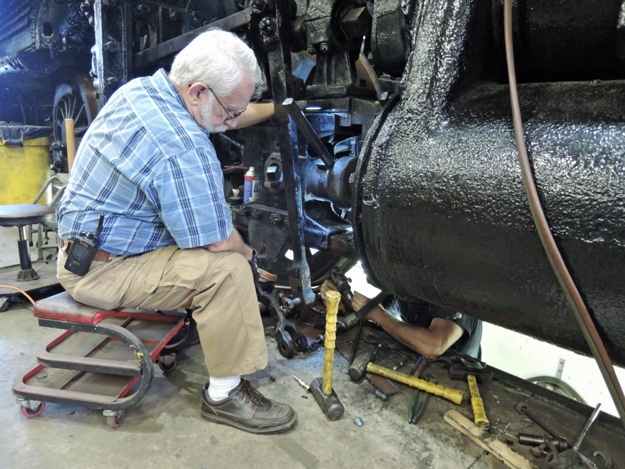 An older man working on a locomotive steam chest
